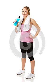 Woman in fitness clothes drinking isotonic drink.