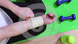 Woman on fitness mat fixing arm injury