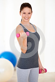Woman, fitness and portrait with dumbbells in gym for health wellness, training and weight loss with exercise. Young