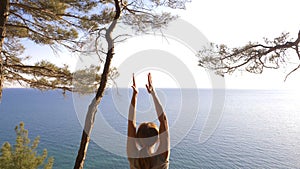 Woman fitness runner on top happy and celebrating success. the woman enjoys the view of the sea from the mountain, she