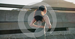 Woman, fitness and running in city for workout, outdoor exercise or cardio training in an urban town. Rear view of