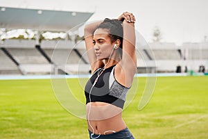 Woman, fitness and stretching arms on stadium track for running, exercise or workout. Active female person or athlete in