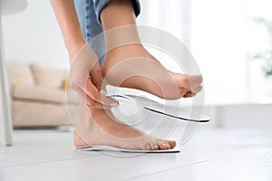 Woman fitting orthopedic insole at home