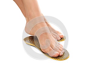 Woman fitting orthopedic insoles on white background, closeup. Foot care