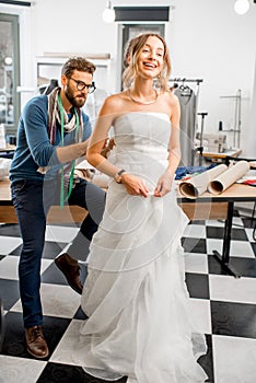 Woman fitting wedding dress at the tailor studio