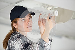 woman fixing broken lamp