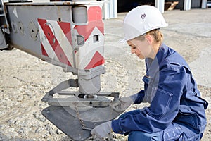 Woman fixing crane`s support leg