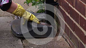 Woman fixing drain cover on house