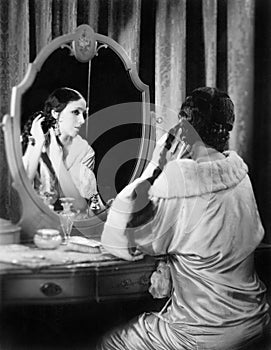 Woman fixing her long hair at her vanity table