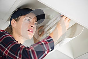 Woman fixing kitchen furniture