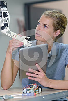 Woman fixing robotic arm