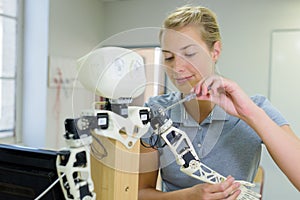 Woman fixing robotic arm