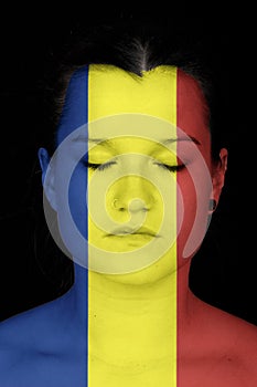 Woman with the flag of Rumania painted on her face. photo