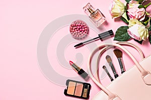 Woman flat lay makup background with cosmetics on pink.