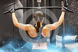 Woman flexing muscles on cable machine in gym