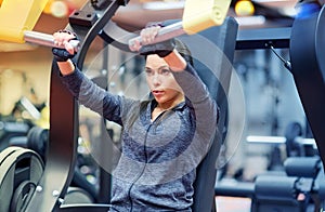 Woman flexing muscles on chest press gym machine