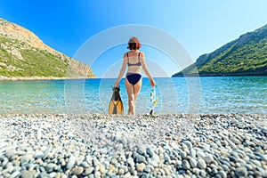 Woman with flippers snorkeling tube on beach