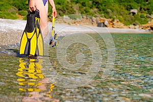 Woman with flippers snorkeling tube on beach