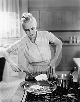 Woman flipping eggs on stove