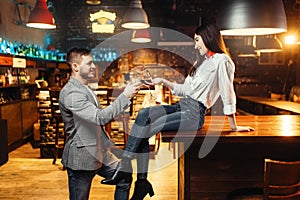 Woman flirting with man, couple at bar counter photo