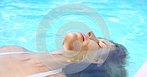 Woman, float and pool relax or outdoor summer fun at holiday destination or resort, travel or paradise. Female person