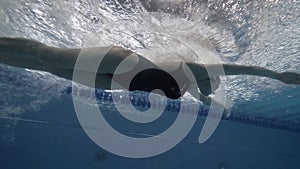 Woman floating butterfly stroke in swimming pool underwater view