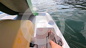 Woman floating on catamaran. Person pedaling with feet and swimming on catamaran