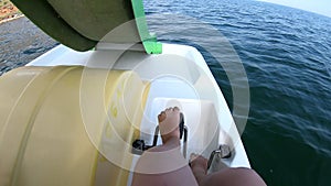 Woman floating on catamaran. Person pedaling with feet and swimming on catamaran