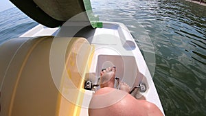 Woman floating on catamaran. Person pedaling with feet and swimming on catamaran