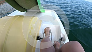 Woman floating on catamaran. Person pedaling with feet and swimming on catamaran