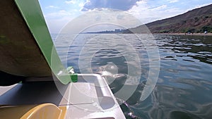 Woman floating on catamaran. Person pedaling with feet and swimming on catamaran