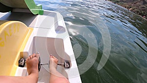 Woman floating on catamaran. Person pedaling with feet and swimming on catamaran