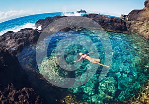 Woman floating in natural pool