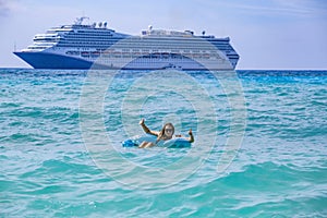 Woman floating in the ocean while on a Cruise vacation