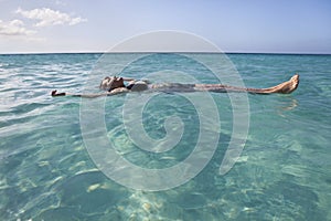 Woman floating and relaxing in the sea photo