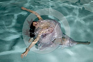 Woman floating under water arms out