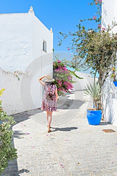 Woman in a floral dress strolling among blue vases in Vejer de la Frontera, Cadiz, Spain photo