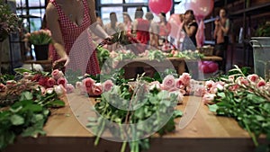 Woman florist arranges flowers on the table