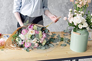 Woman florist creating beautiful bouquet in flower shop. Working in flower shop. Girl assistant or owner in floral