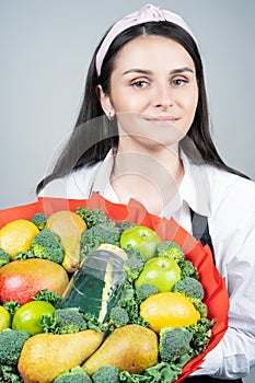 Woman florist with an edible bouquet in her hands.Photo in the studio. Concept. Naturalness, Floral arrangement, florist`s tricks, photo