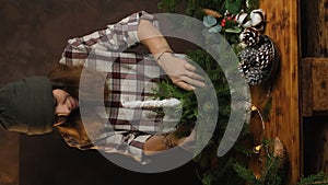 Woman florist making Christmas flower arrangement. Vertical video.