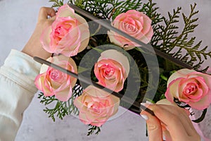 Woman florist making flowers bouquet Flowers arrangement in box created by florist wedding gift. Rose roses bouquet