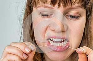 Woman flossing teeth with dental floss