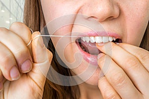 Woman flossing teeth with dental floss