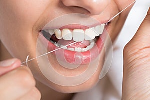 Woman Flossing Teeth At Home