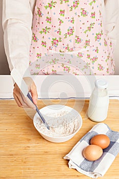 Woman with flour and baking ingredients