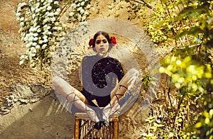 Woman with flower in mouth sitting on chair