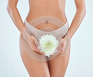 Woman, flower and natural feminine hygiene in studio for body, health and wellness on white background. Menstruation