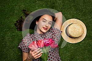 Woman with flowers lying on grass