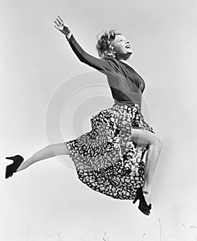 Woman in a flowing skirt leaping through the air photo